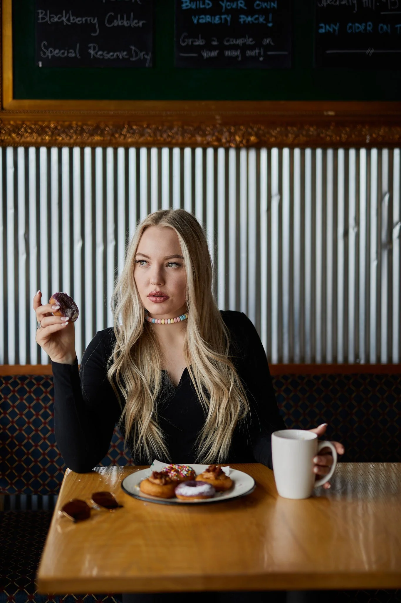 Model posing with doughnut in hand at FOCO DOCO in Fort Collins