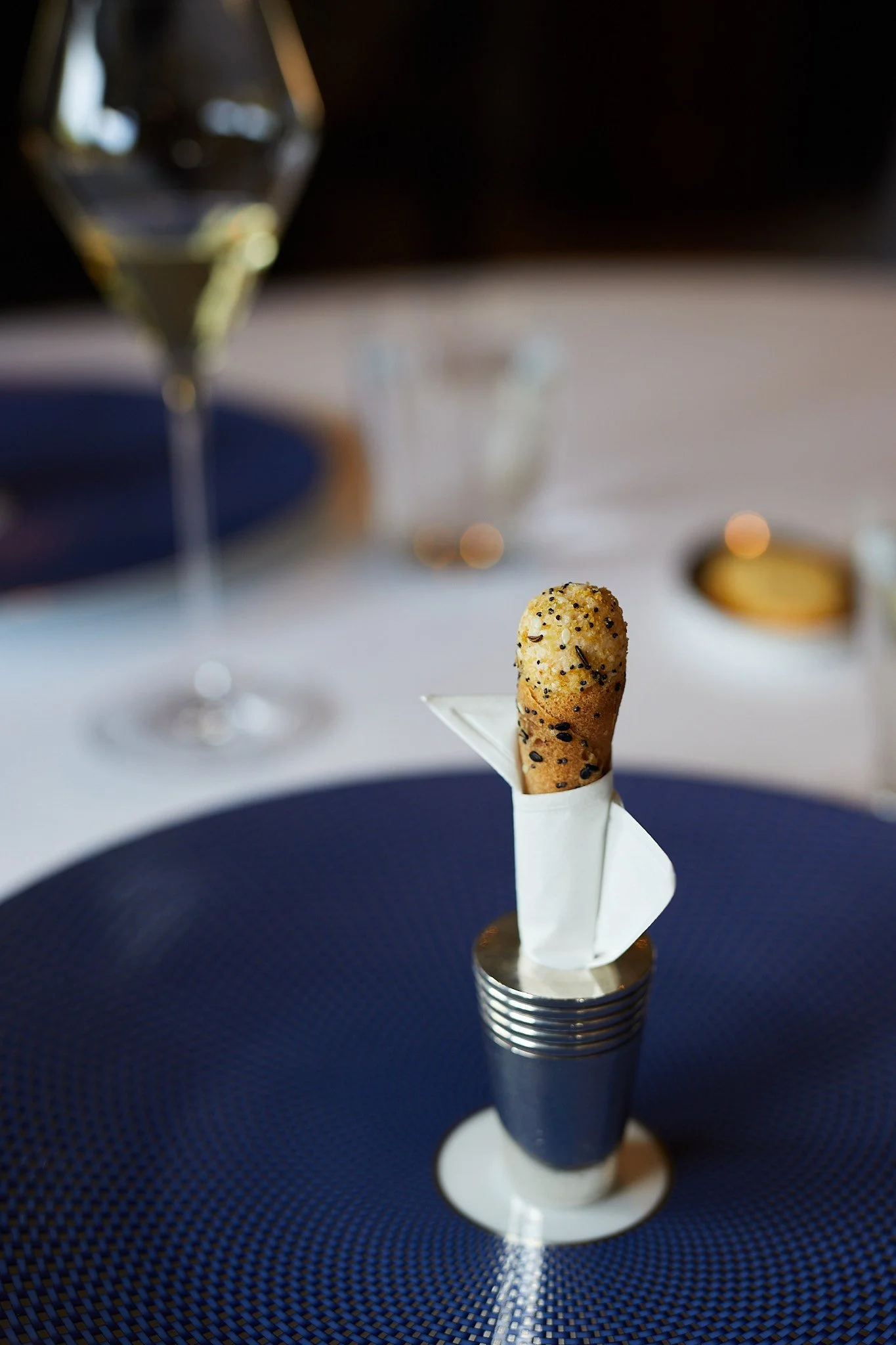 A smoke salmon cornet at the French Laundry on a blue plate at a fine dining restaurant table.