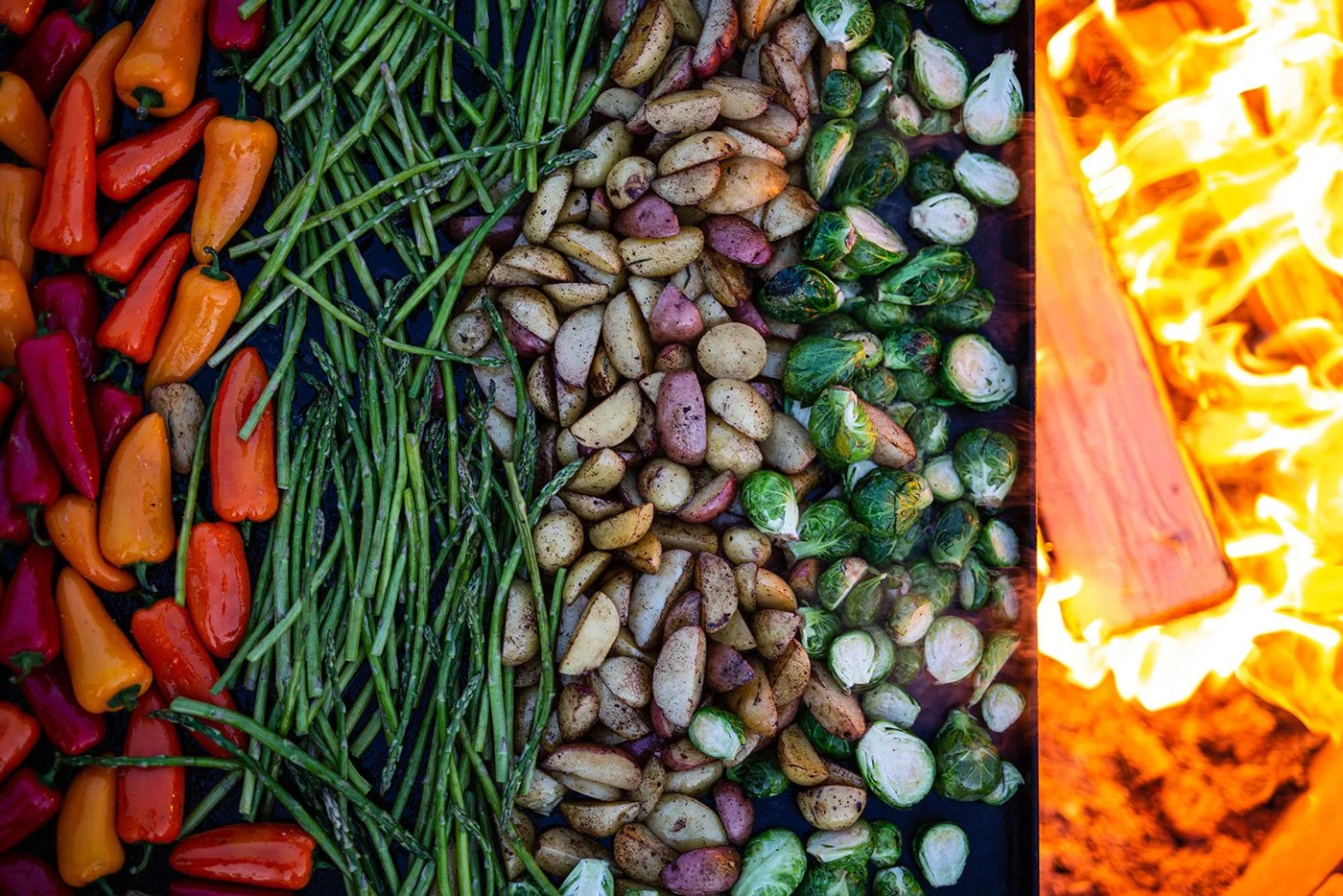 Evening separated vegetables on griddle roasting over an open fire