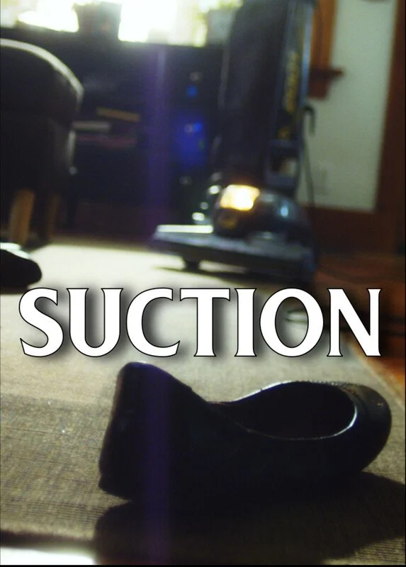 A single black clog on a brown carpet in a cozy room with a vacuum cleaner and furniture in the background, with the word 'SUCTION' overlaid.