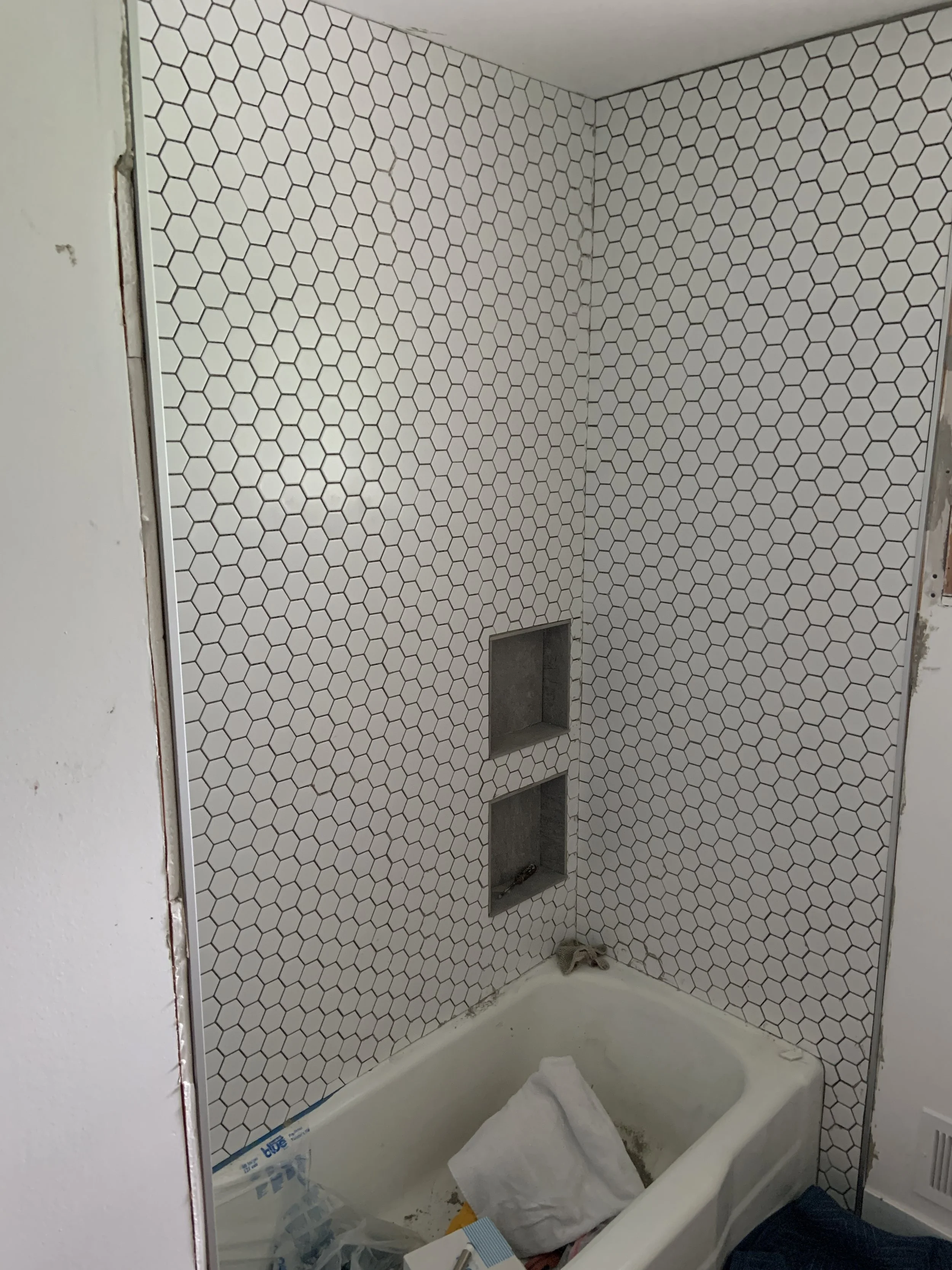 Tiled a tub/shower surround with a beautiful hexagon tile.