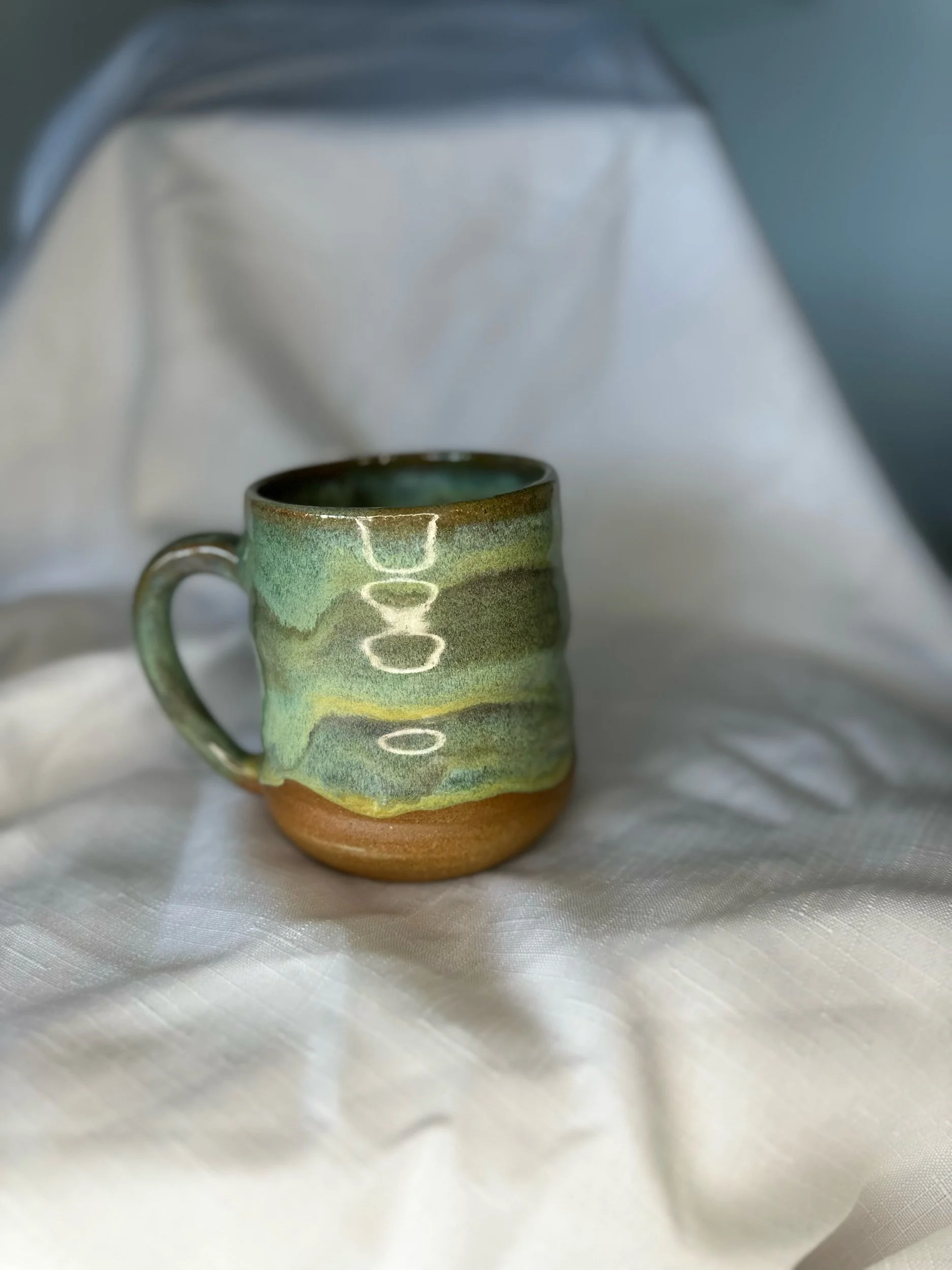 Green glaze melt on brown clay.