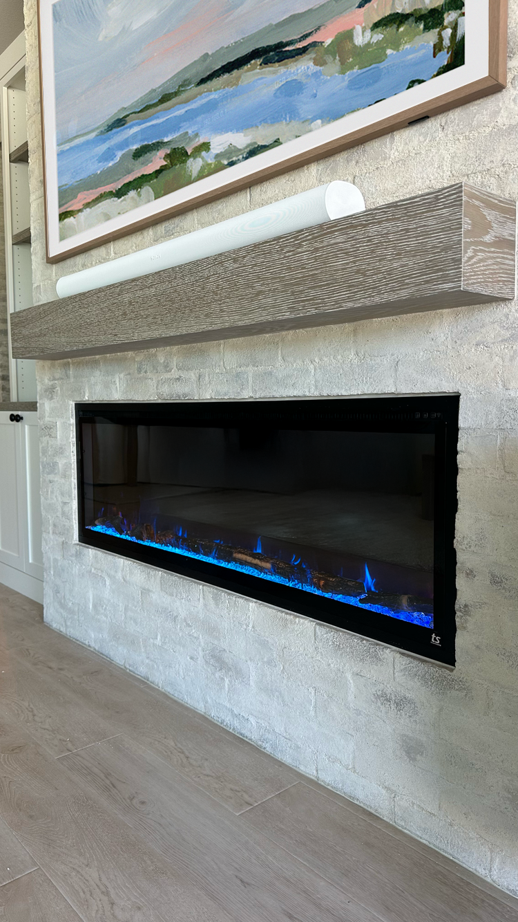This is a new home in San Marcos. We designed a 16" bump out for an electric linear fireplace, with mantel & side cabinets all matching the customers rustic distressed table. A SONOS soundbar handles TV sound and music with a SONOS sub hidden elsewhe