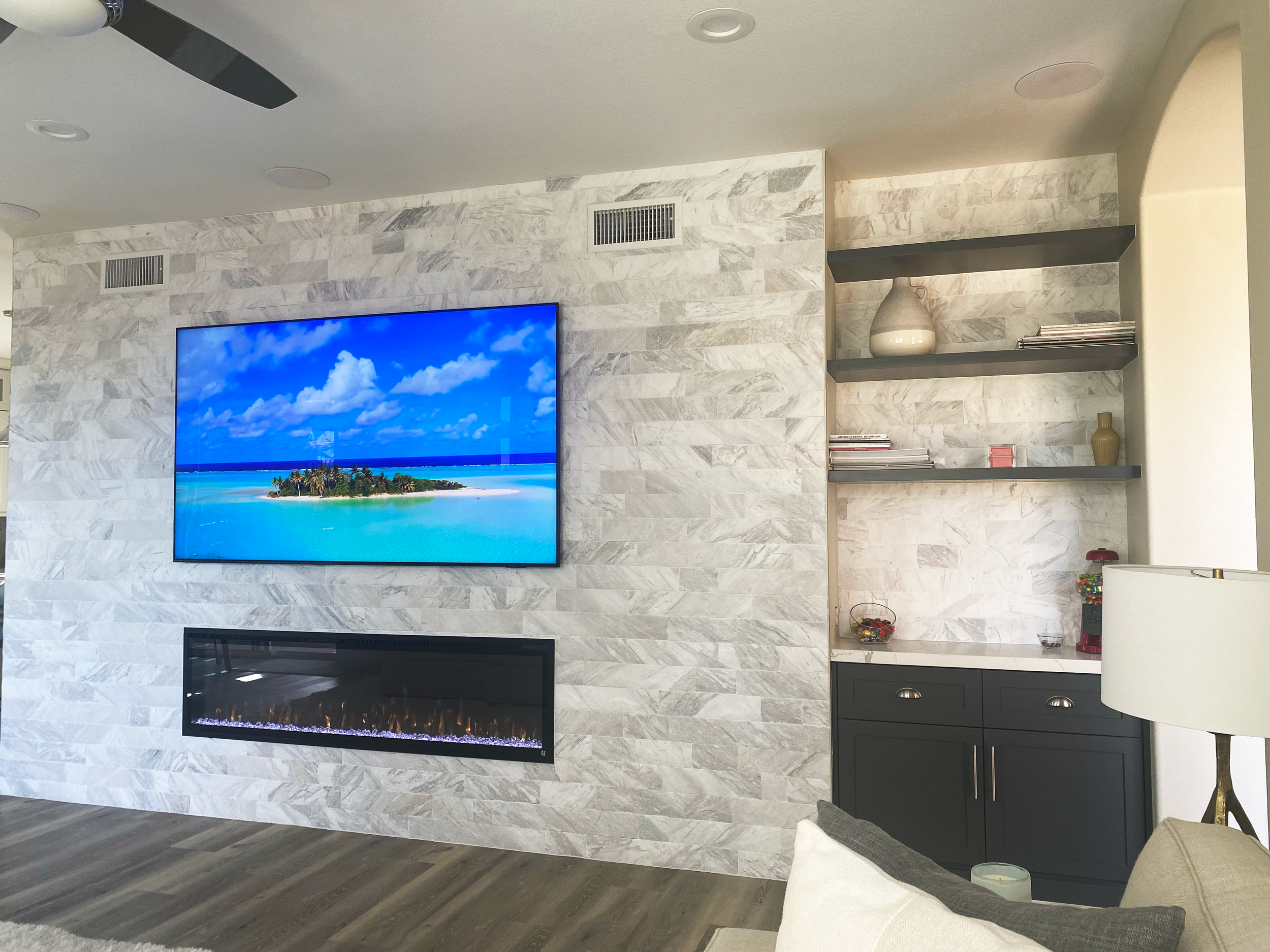 This beautifully remodeled home in La Costa Valley in Carlsbad featured a demo of the hearth and slight bump out to house a large TV & electric linear fireplace.  The complimentary side cabinet houses the full AV system with surround sound & SONOS mu