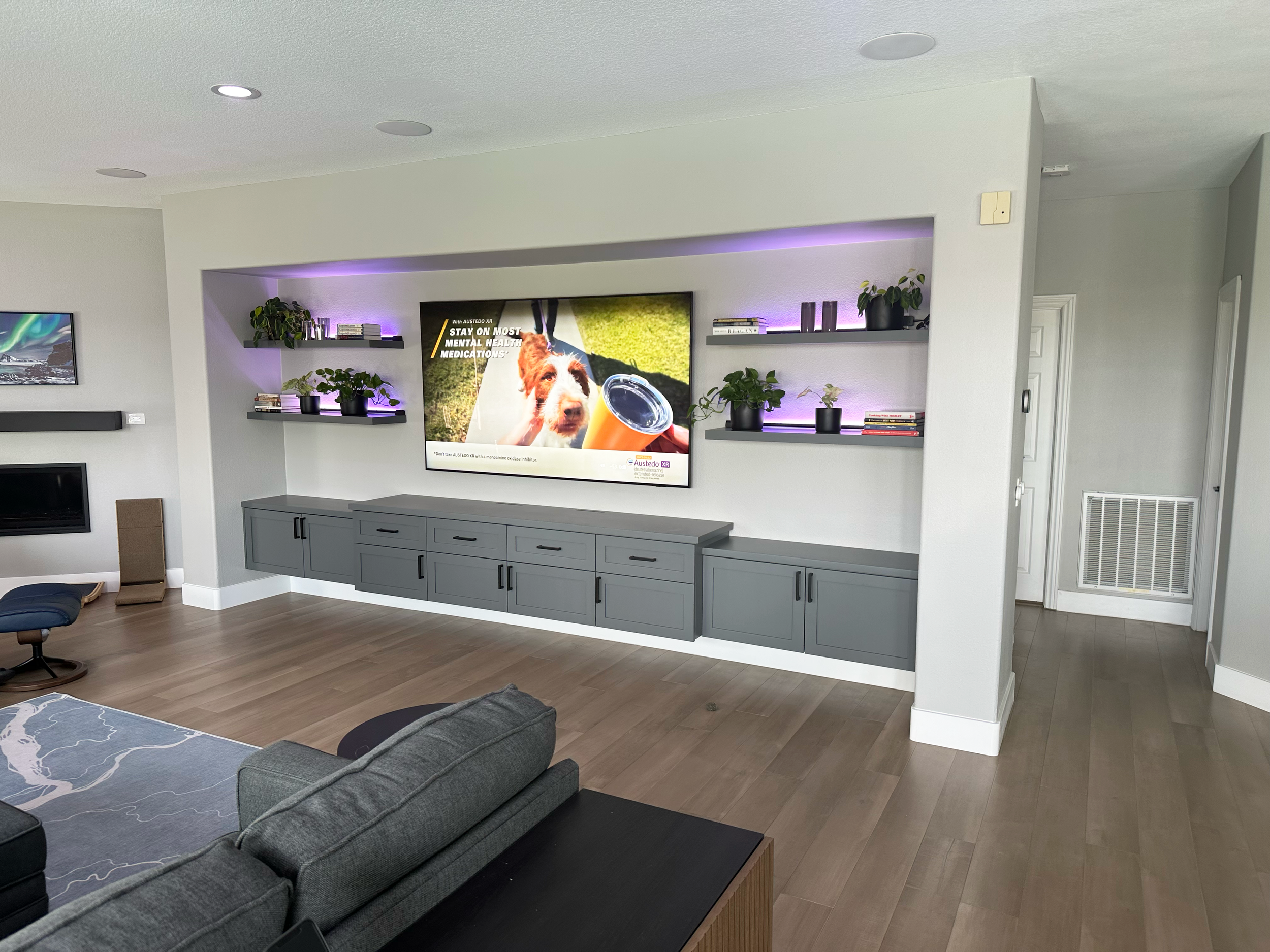 Customer in Rancho Carillo Carlsbad with a custom floating cabinet with lighted floating shelves. Flush mount speakers & hidden equipment complete the AV system without looking like a "mancave".