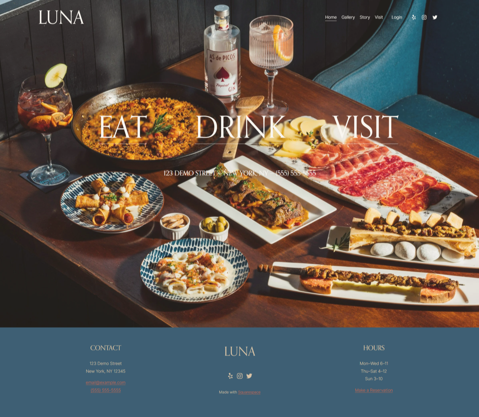A restaurant website homepage with a header that says 'LUNA' and menu options, including Home, Gallery, Story, Visit, and Login. The main background features a table filled with a variety of food and drinks, including a cheese and charcuterie board, a large pan of paella, a plate of fried roll tacos, a dish with grilled vegetables and meat, and several drinks such as gin and tonic, and a cocktail with lemon slices. The footer contains the restaurant's contact information, hours, and social media icons.