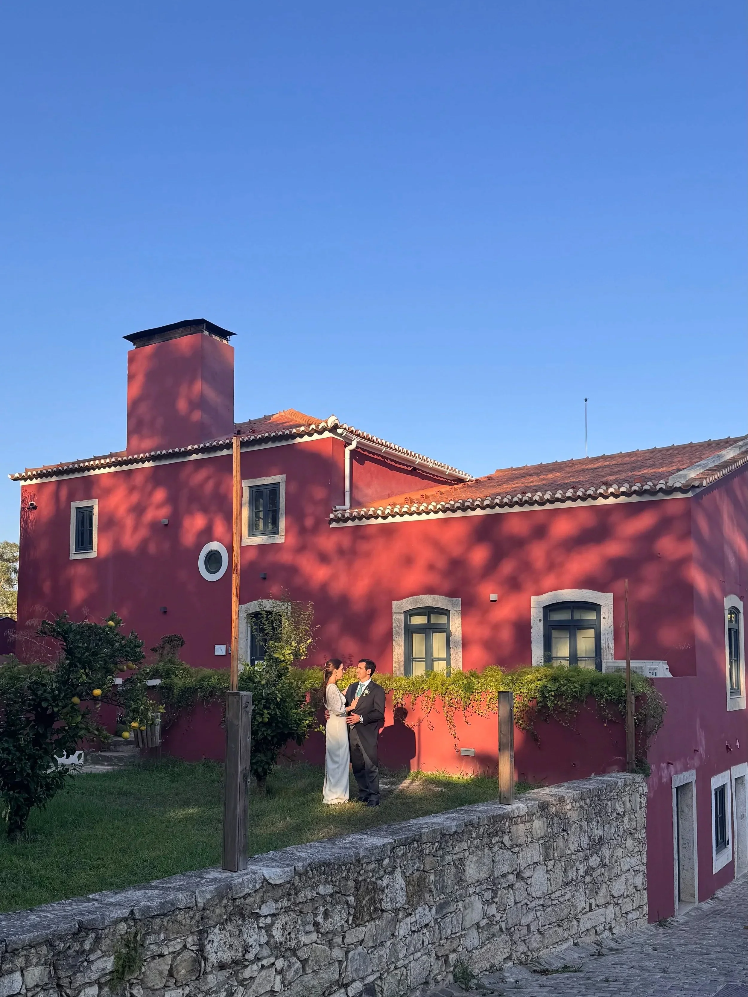casa vermelha da quinta da pimenteira em lisboa, com casal de noivo no momento da sessão de fotografias.