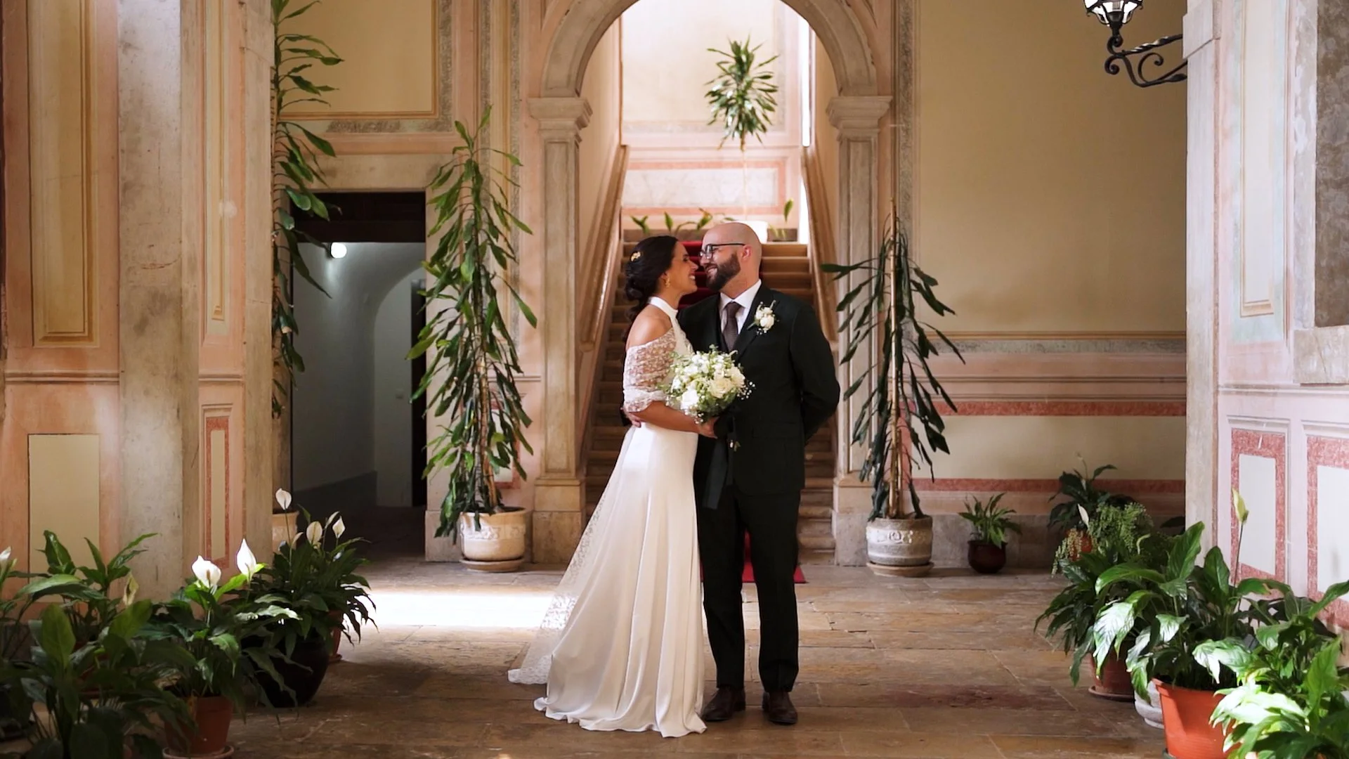 Casal de noivos sorrindo juntos frente a frente na basílica de meca após terminar a celebração do matrimónio