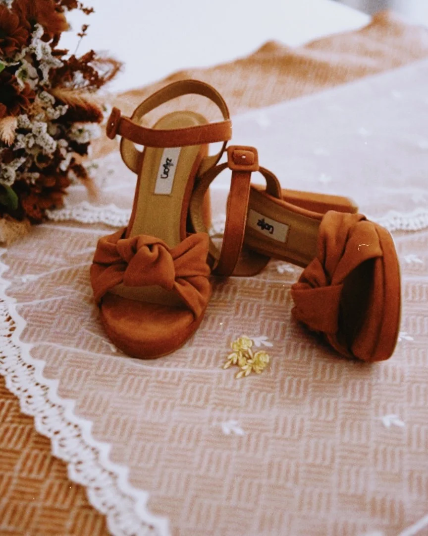 sapatos de noiva terracota sobre a renda do véu e um pouco do bouquet, numa composição elegante de registo ao casamento
