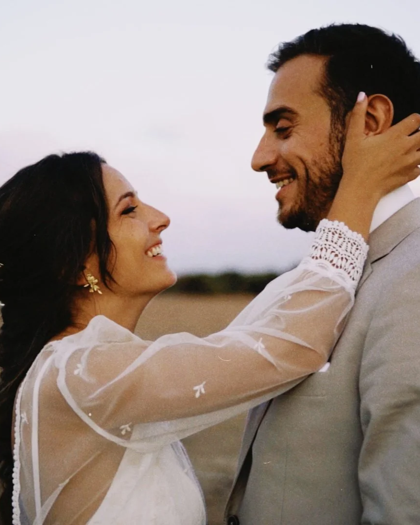 Casal noivos feliz em um momento romântico ao ar livre, sorrindo e olhando um para o outro, com fundo desfocado de natureza no Alentejo