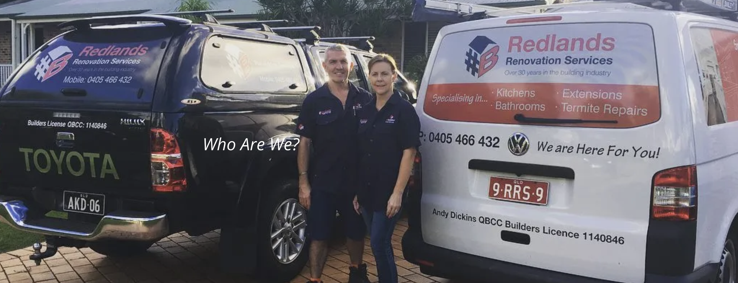 Two workers standing in front of branded service vehicles for Redlands Renovation Services, with a black Toyota pickup truck and a white van, displaying the company's logo and services, outdoors during daytime.