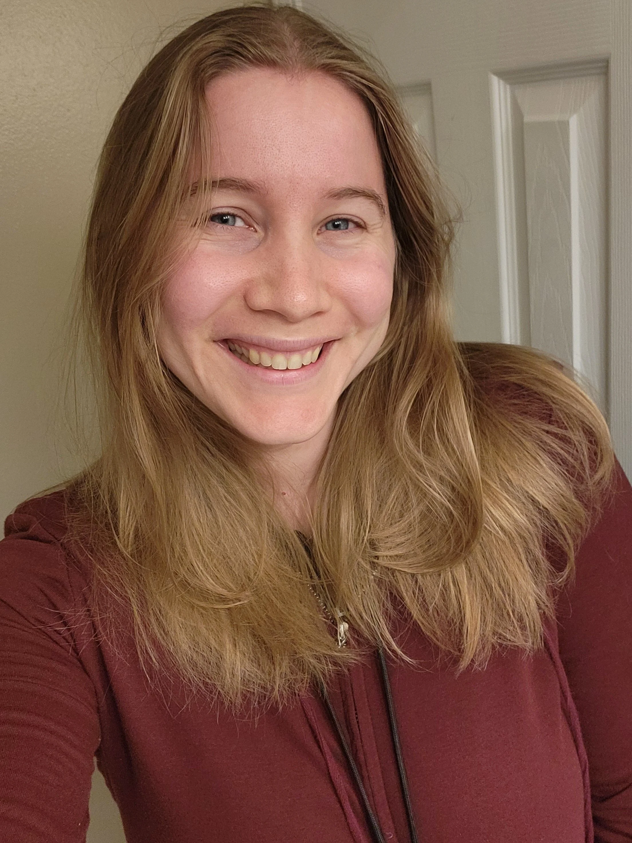A young woman smiles eagerly at the camera. She has long blonde hair and blue eyes and is excited to be your local face painter for your southern wisconsin gathering!