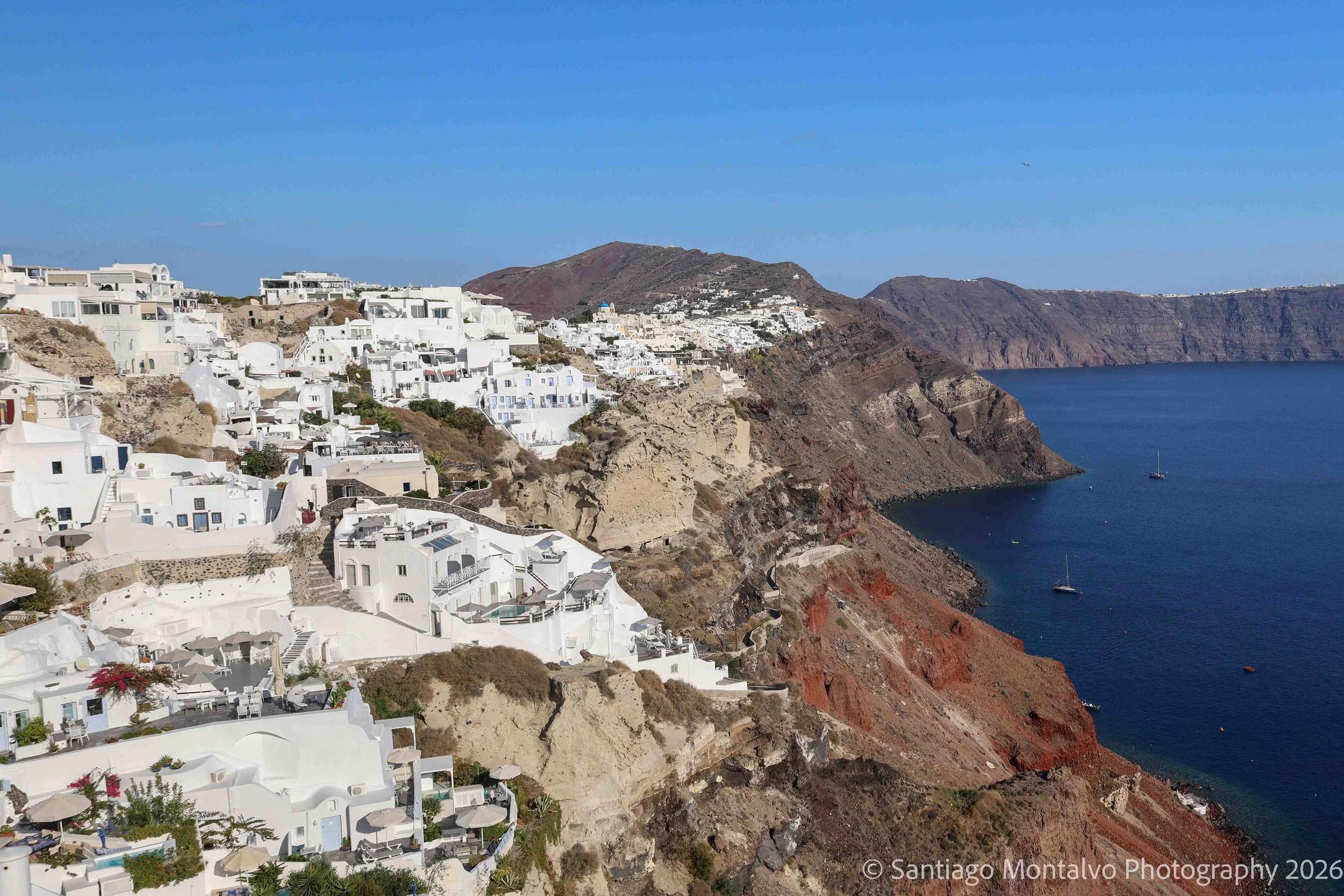 White Above Blue — Santorini, Greece. Whitewashed village architecture meets the immense blue expanse of the Aegean Sea.