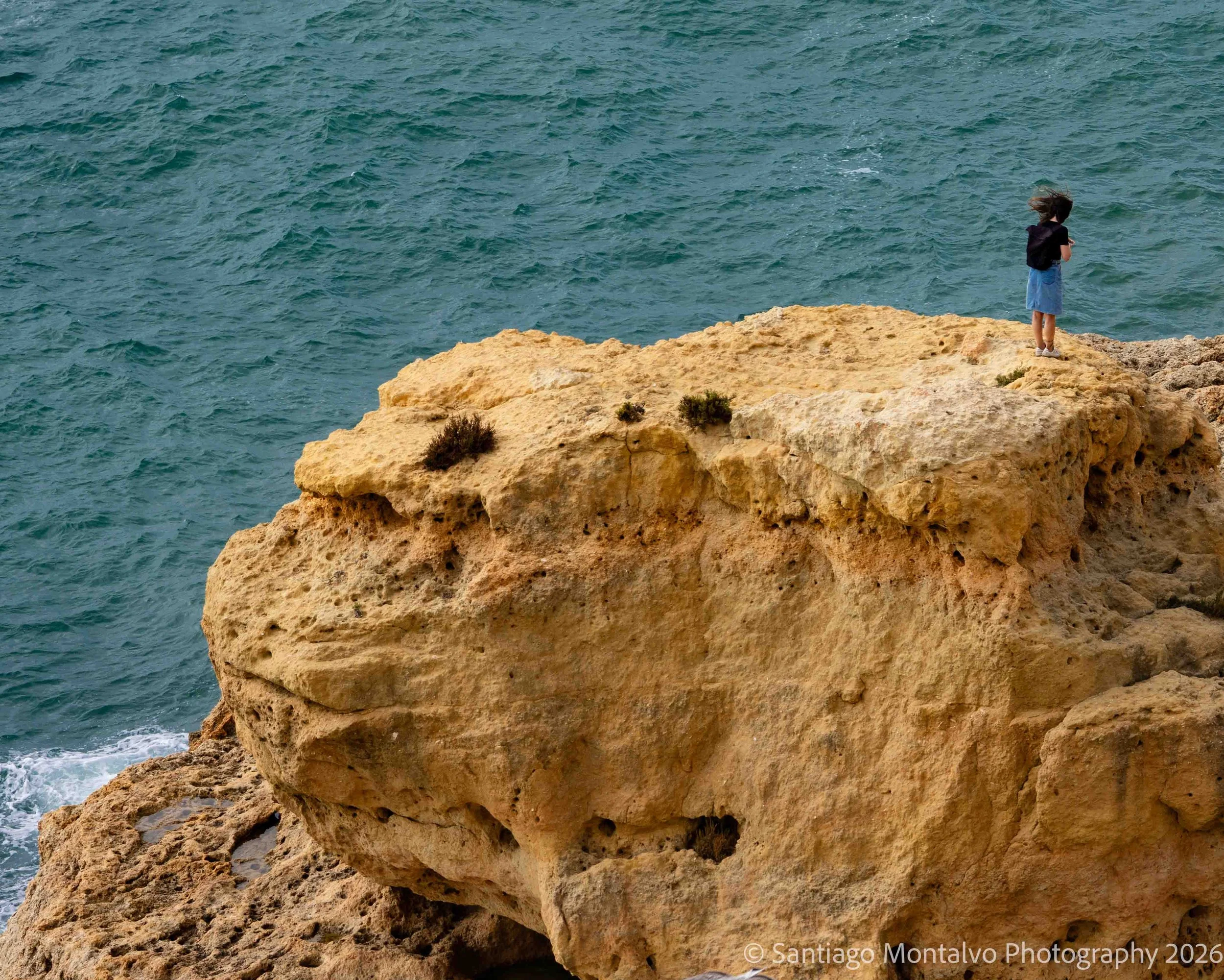 At the Edge — Lagos, Portugal. A solitary figure pauses above the Atlantic coast.