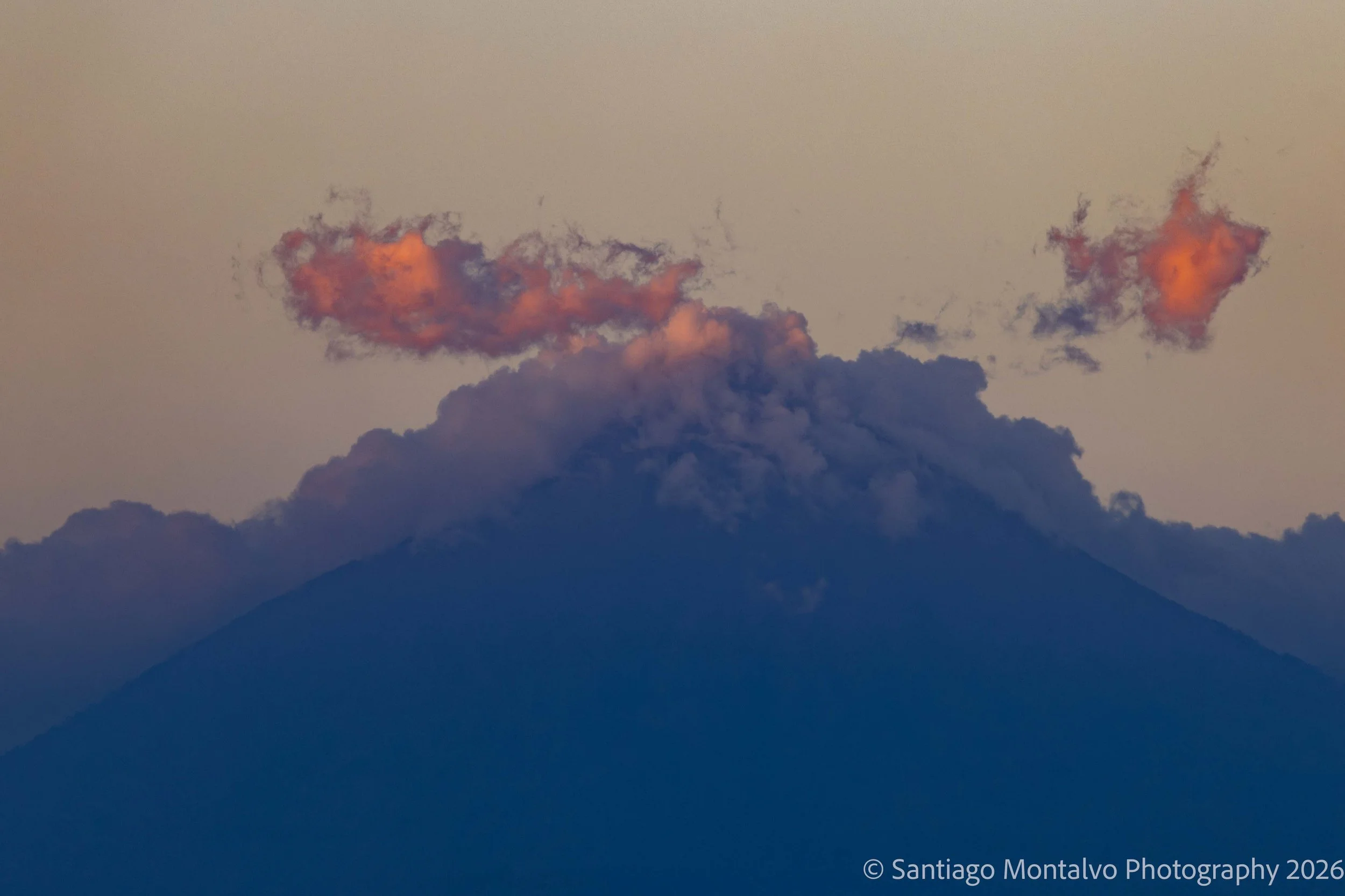 Volcano at Dusk — Guatemala. A dramatic volcanic silhouette beneath clouds touched by the last light of day