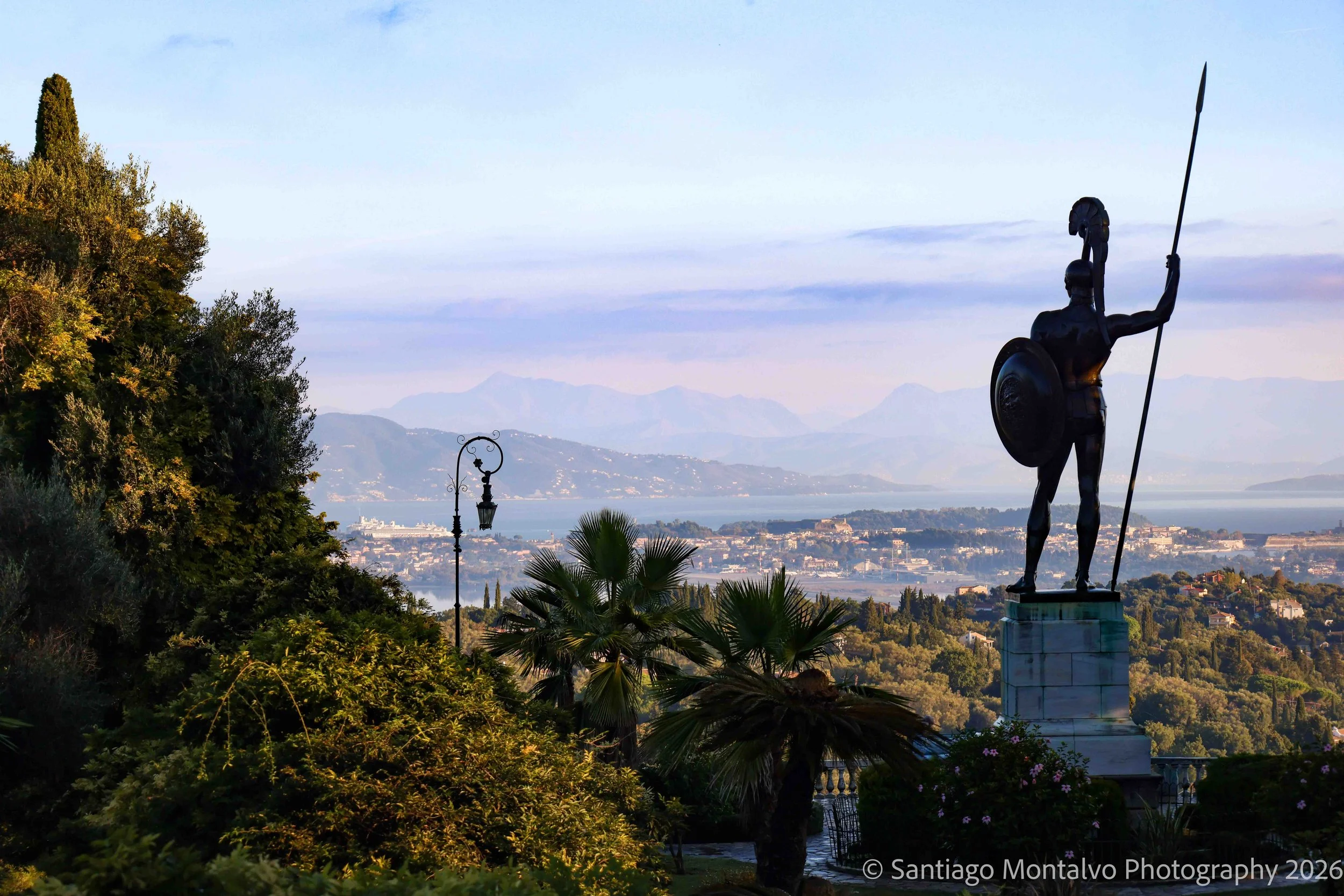 The Warrior and the Horizon — Corfu, Greece. A dramatic classical sculpture stands against the timeless landscape of the Greek islands.