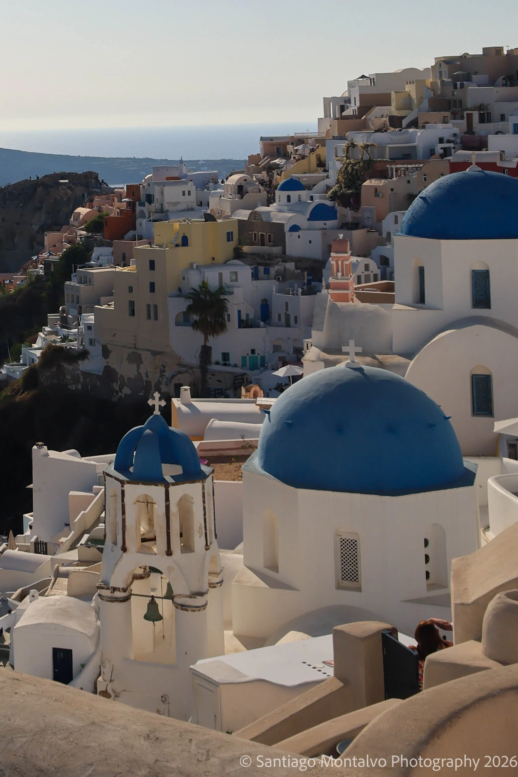 Blue Domes Above the Sea — Santorini, Greece. Whitewashed buildings and blue-domed churches cascade across the island's dramatic landscape.