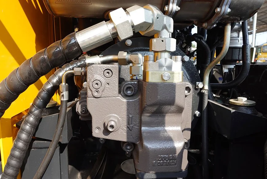 Close-up view of hydraulic components and hoses on heavy machinery.