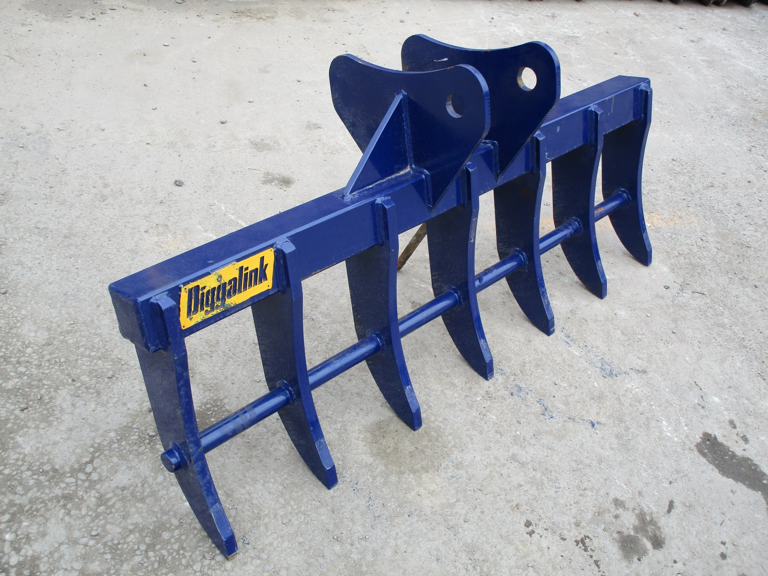 A set of blue metal trackless train manual switchers on gray concrete ground.