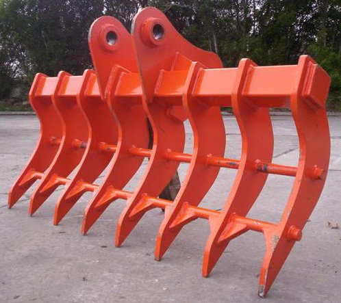 Multiple orange excavator buckets lined up on a paved surface.