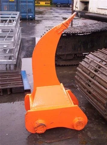 Orange hydraulic excavator boom with arm and bucket attachment in a construction yard