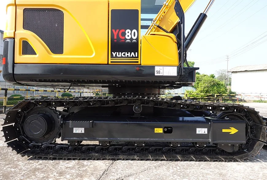 Close-up of a yellow Yuchai YC80 excavator, showing the side view of the machine with black tracks and hydraulic arm.