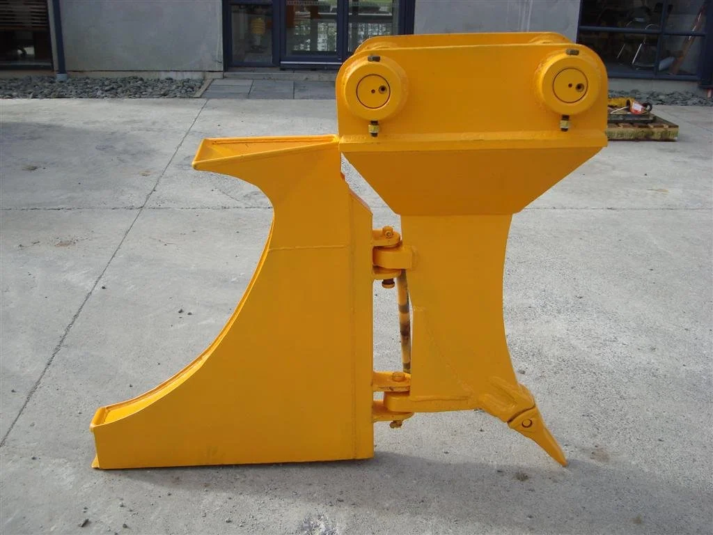 A yellow metal sculpture resembling a stylized animal, possibly a dog, with circular shapes for eyes and a simple body, placed on a concrete sidewalk in front of a building.