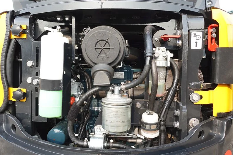 View of a machine engine compartment with various components including a white and green fluid container, black air filter, hoses, and metallic parts.