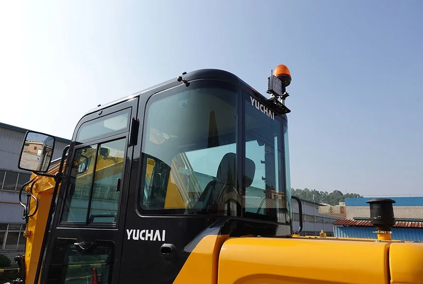 Close-up of a yellow and black construction vehicle with a cabin, labeled 'YUCHAI', on a clear day.