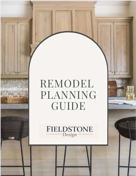 Remodel planning guide sign in a modern kitchen with wooden cabinets and black chairs.