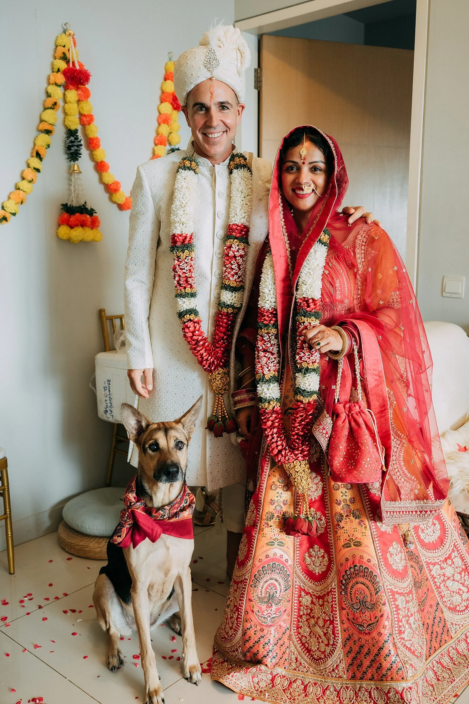  A unique family portrait of the bride and groom with their dog, combining traditional attire with personal storytelling. 