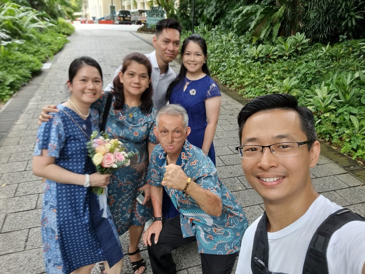 Photographer taking a selfi photo with his client family after an outdoor shoot
