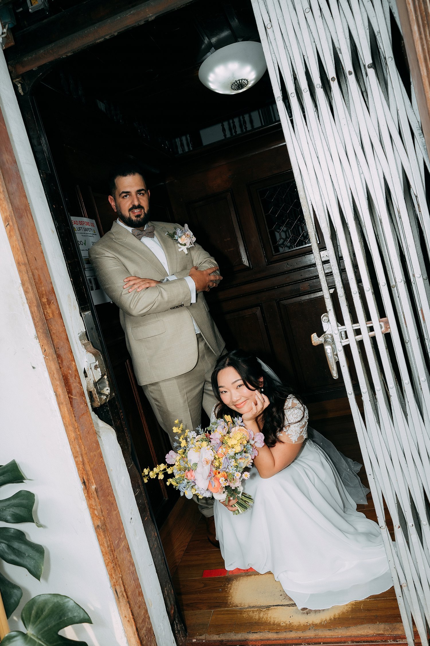 Couple posing inside the 1929 heritage manual gate lift at Kada Maxwell