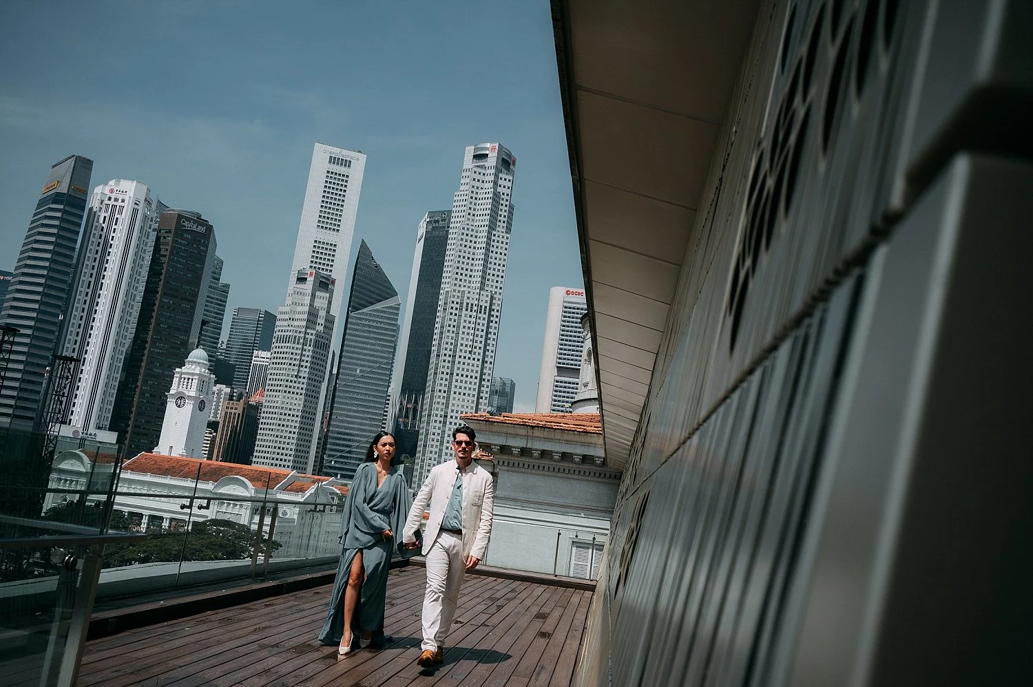 Candid engagement photography in Singapore capturing them walking the museum roof with Singapore Skyline as backdrop