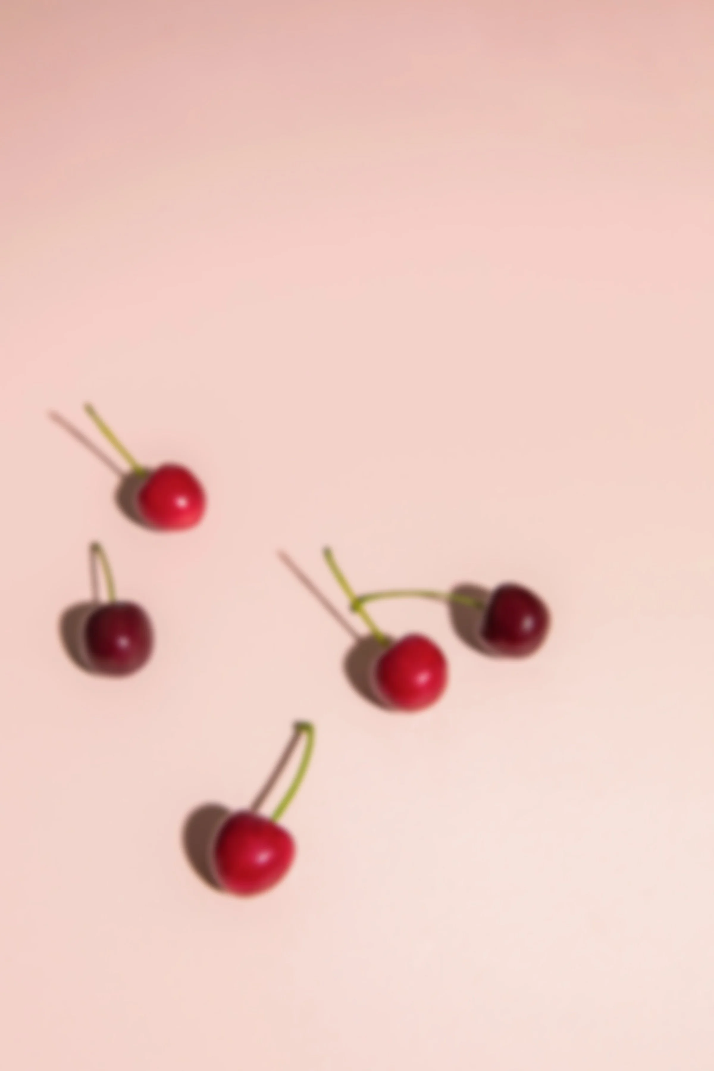 cherries on a pink surface