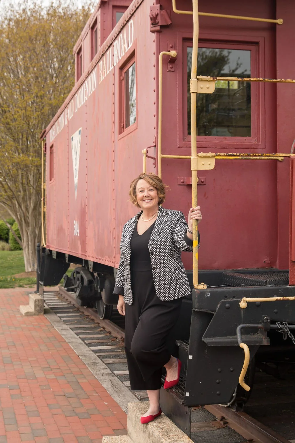 Northern Virginia Realtor LeAnne Anies posing beside historic train car in downtown Herndon VA