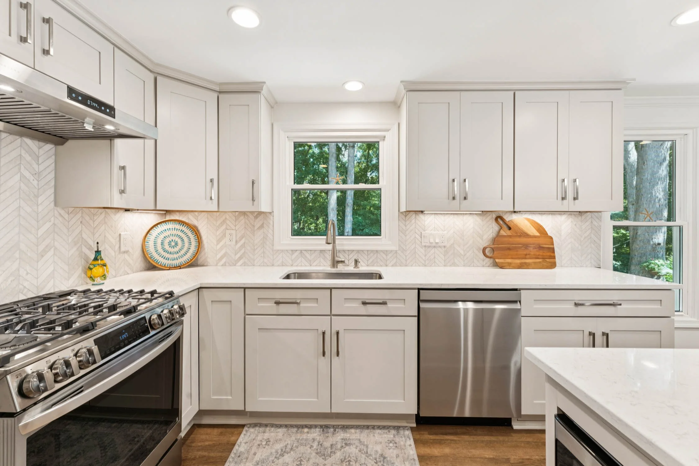 Modern kitchen with stone-colored cabinetry and herringbone tile backsplash in a Northern Virginia property