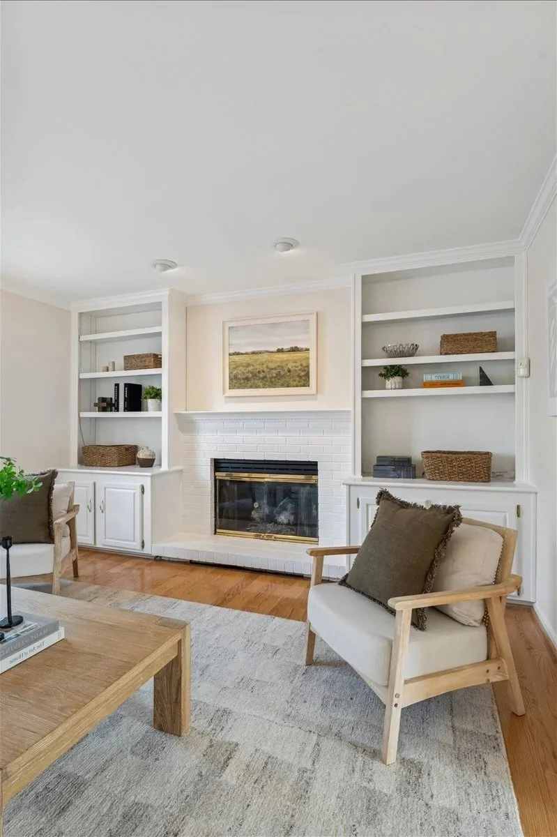 Bright Northern Virginia dream home living room with white fireplace and custom built-in shelving