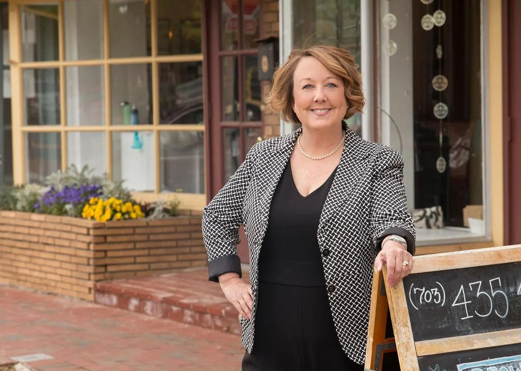 Portrait of Northern Virginia Realtor LeAnne Anies walking along a charming downtown street in Northern Virginia