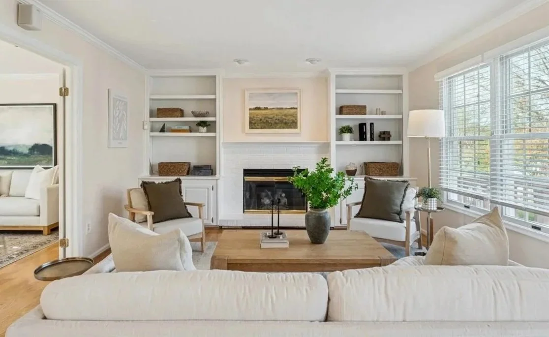 Bright luxury living room with white sofas and built-in shelving around fireplace in Northern Virginia home