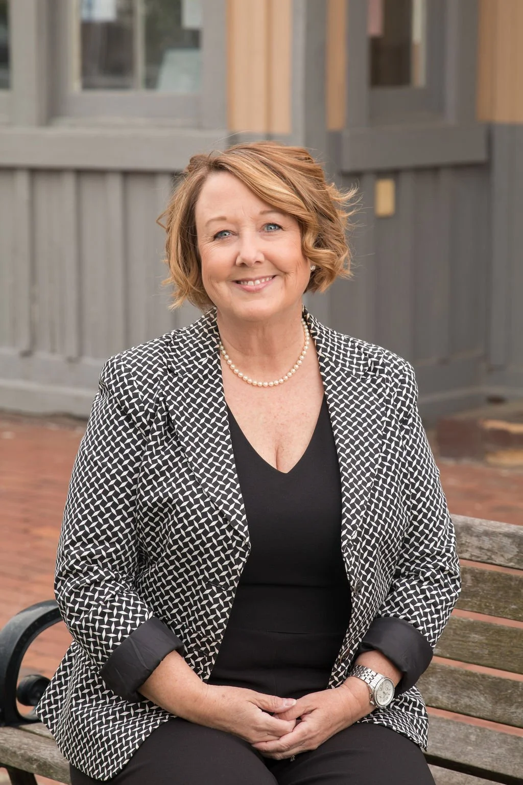 LeAnne seated outdoors on a bench in Herndon Virginia neighborhood setting