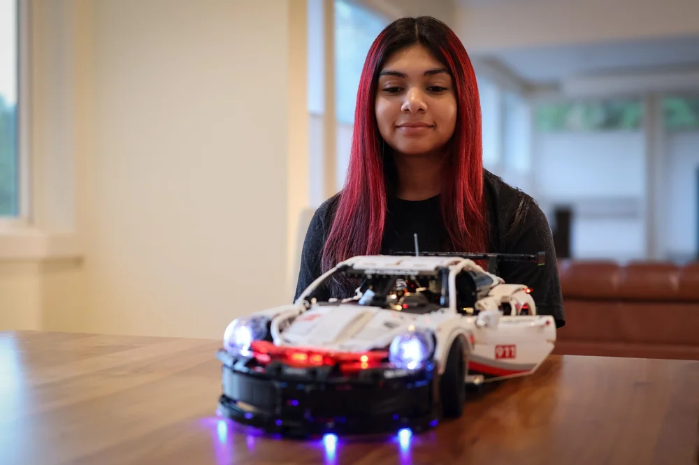 Ana Palestro at 16 in October 2026, with her lit-up LEGO Technic Porsche 911 RSR