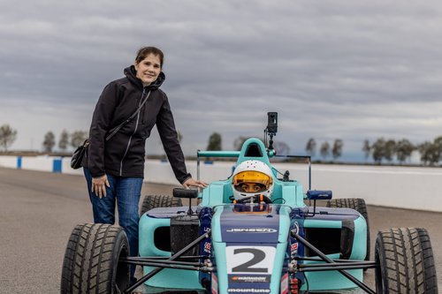 A supporter standing beside Ana Palestro as she sits in her #2 F4 car