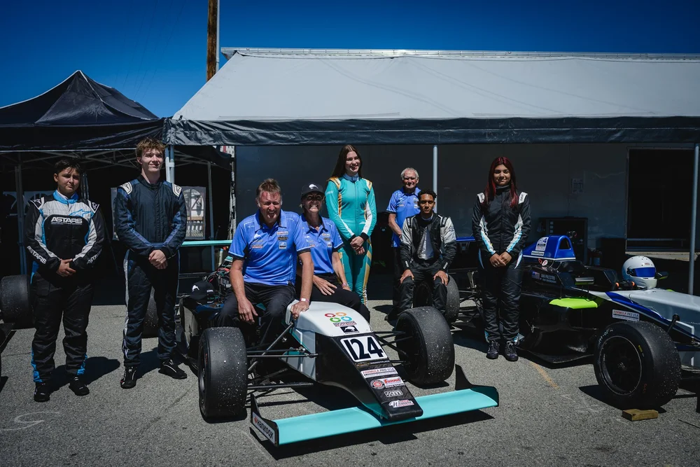 Kiwi Motorsport drivers and crew, including Ana Palestro, with their F4 cars at Laguna Seca, June 2026