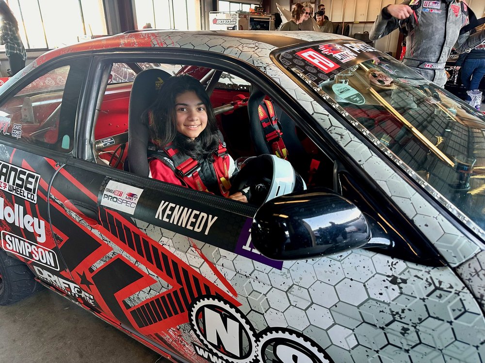 Ana Palestro smiling from the passenger seat of Zandara Kennedy's drift car at Sonoma Raceway