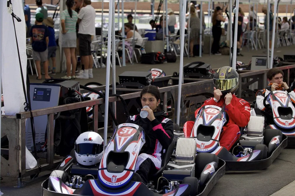 Drivers, including Ana Palestro, seated in their karts in the pit lane at the K1 U.S. Finals at K1 Circuit