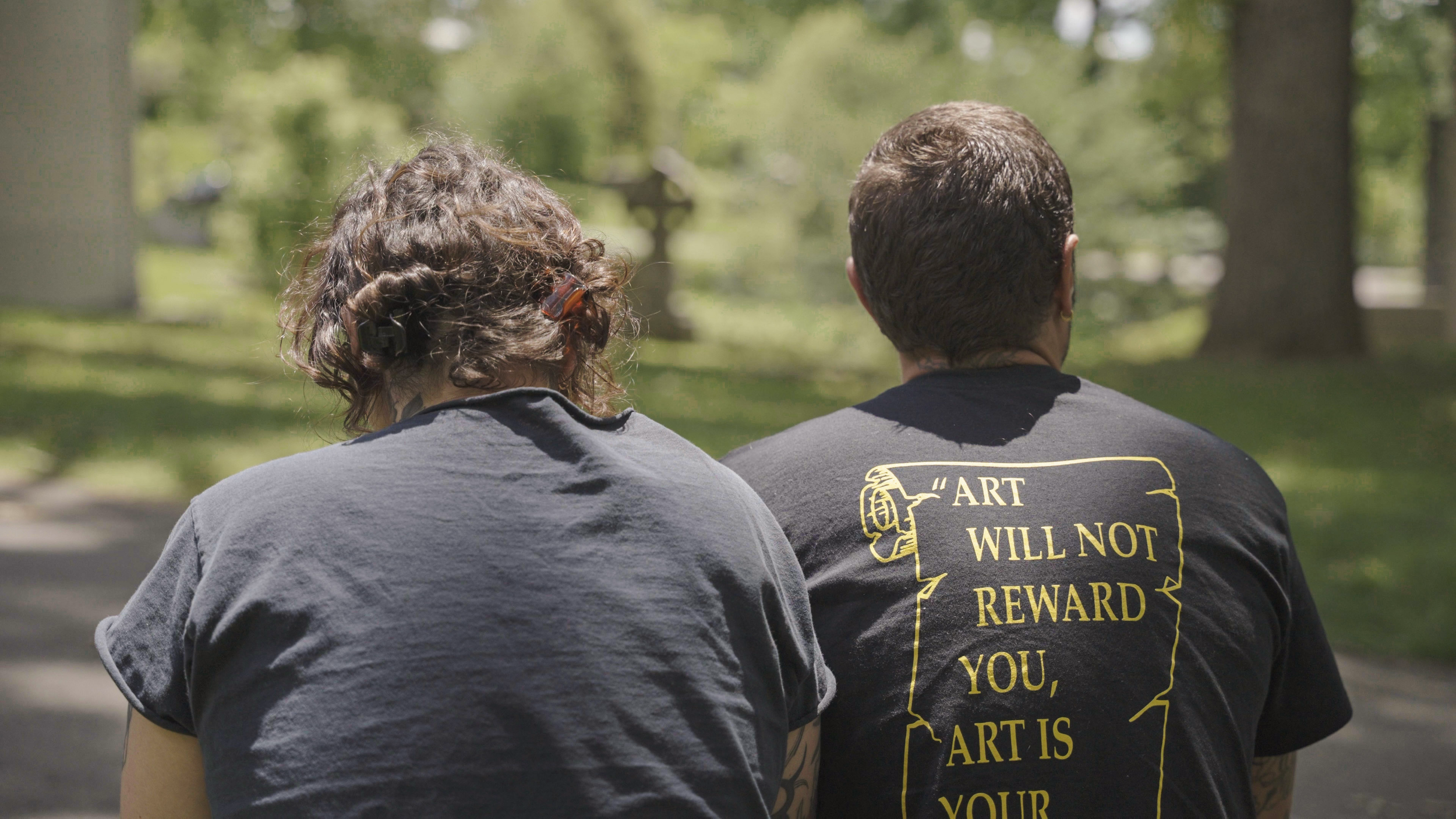 Baylen Levore and Shane Donaldson visit a cemetery in Asheville, N.C., on May 13, 2025. Donaldson's shirt reads: "Art will not reward you, art is your reward."