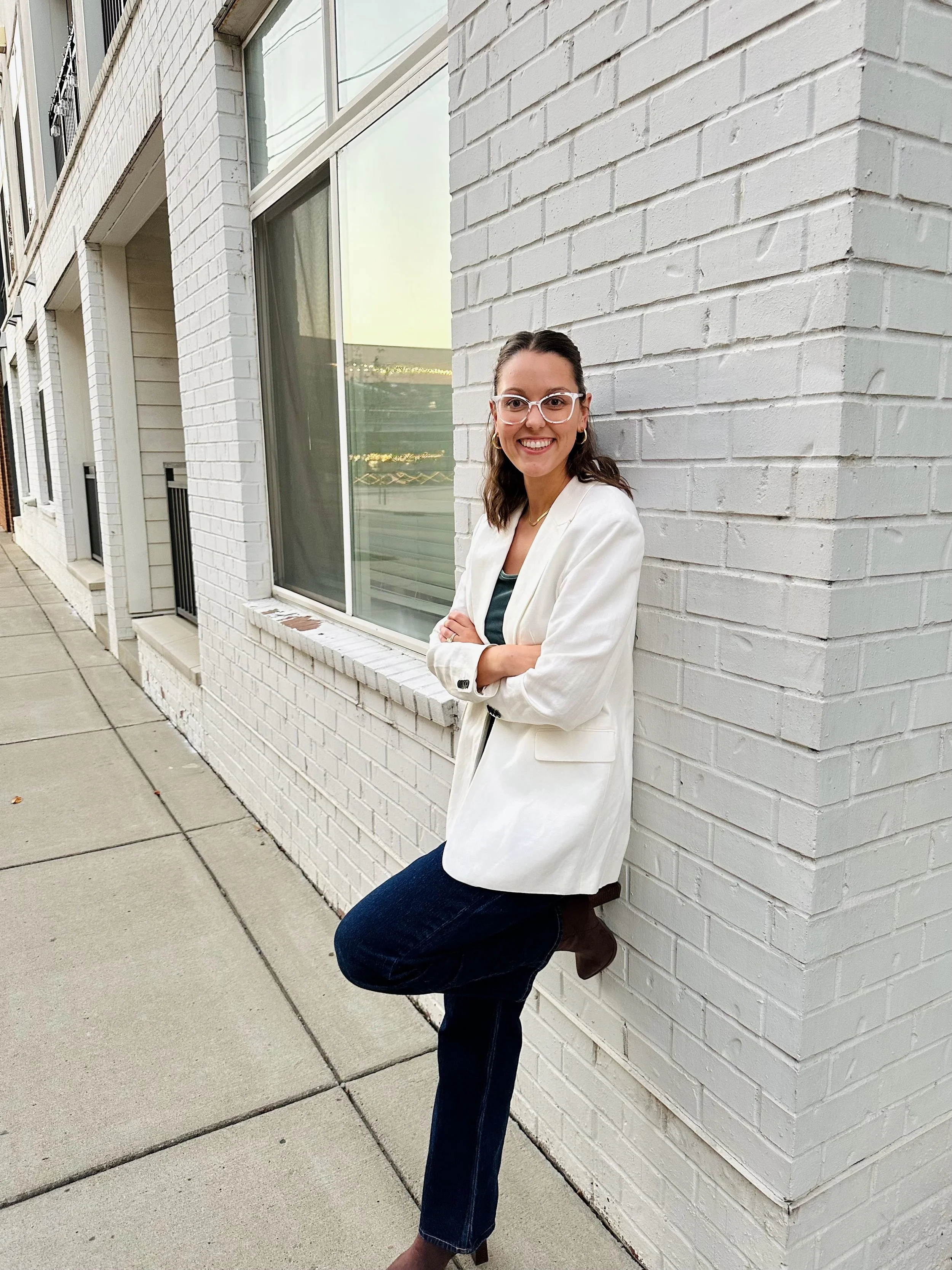 Dr. Hadorn leaning against a white wall smiling at the camera