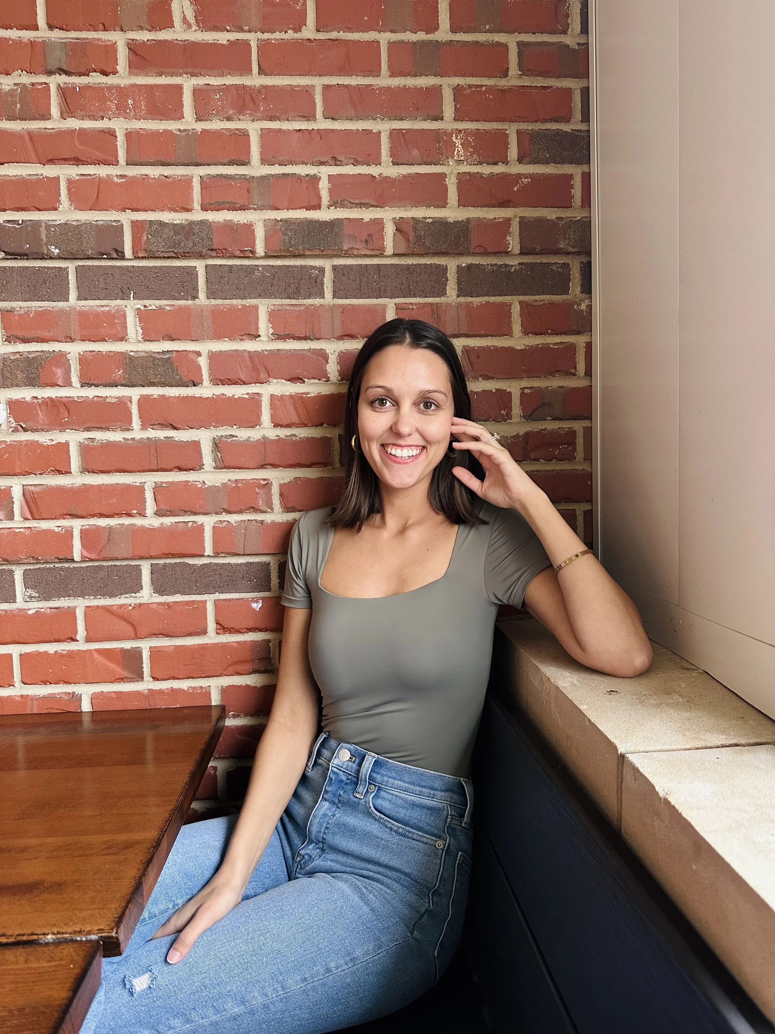 Photo of Dr. Hadorn sitting with a brick wall behind her.