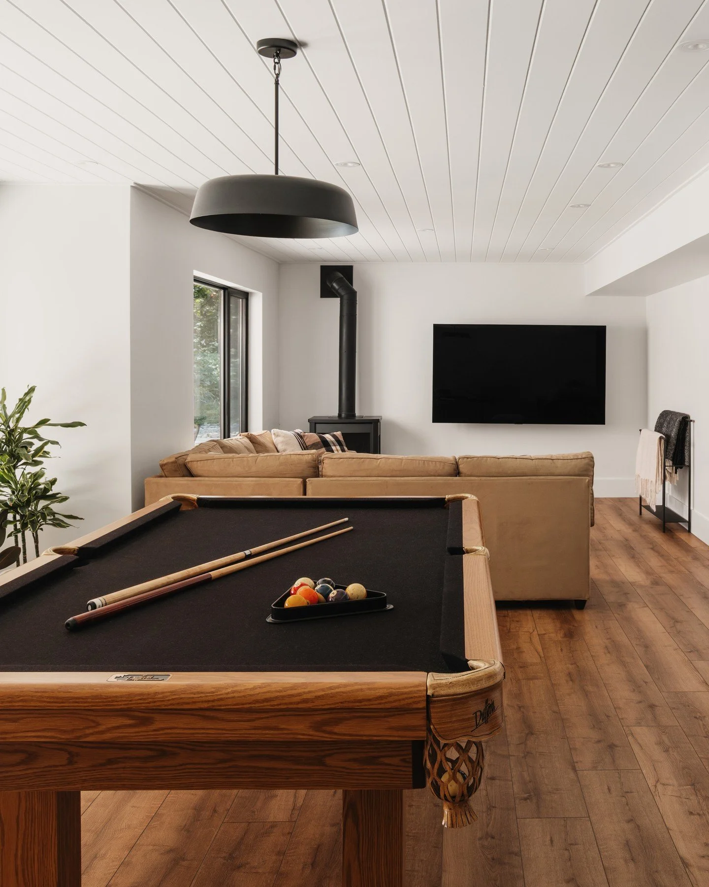 A complete interior and exterior renovation, paired with structural enhancements, allowed us to completely reimagine this lower-level game room in our Dickie Lake cottage.⁠
⁠
Panelled ceilings and exposed timbers create a warm, inviting atmosphere de